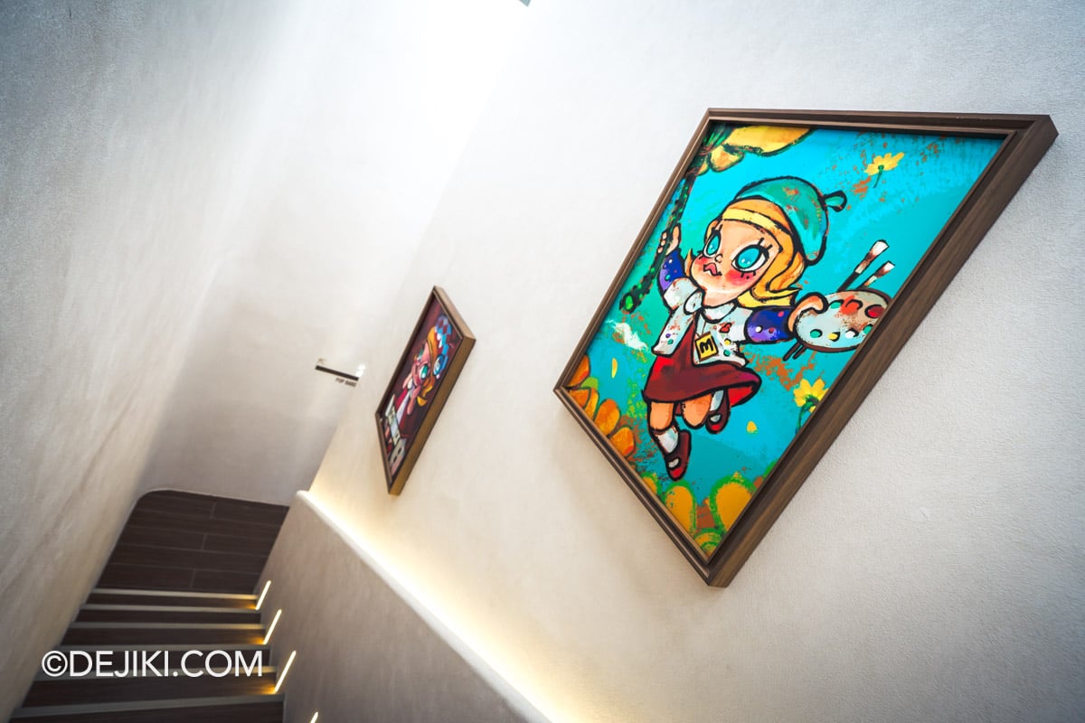 POP BAKERY Singapore at Resorts World Sentosa - Cafe Entrance Staircase with Framed POP MART Art Staircase up to POP BAKERY, lined with framed POP MART character artworks under picture lights