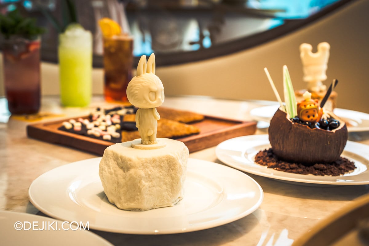 POP BAKERY Singapore at Resorts World Sentosa - Menu showcase LABUBU David Art cake closeup LABUBU David Art Cake at POP BAKERY, a white LABUBU figure standing on a mascarpone and cocoa coffee sponge base