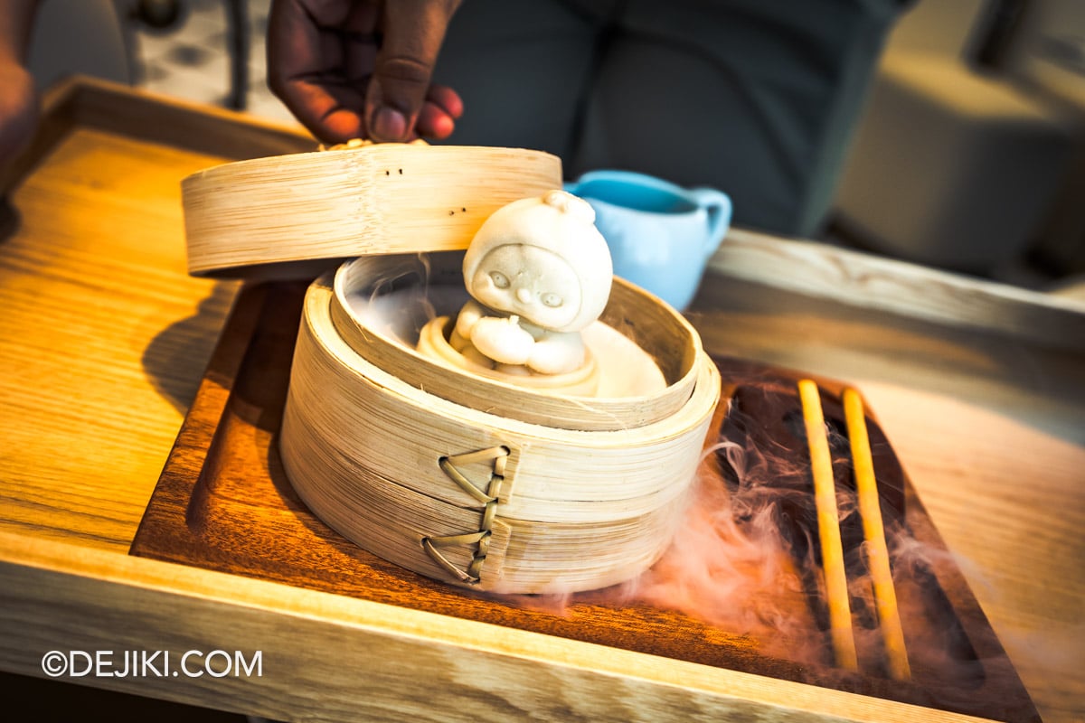 POP BAKERY Singapore at Resorts World Sentosa - Menu showcase PUCKY Xiao Long Bao presentation with foggy mist PUCKY Xiao Long Bao dessert served in a bamboo steamer basket with rising mist